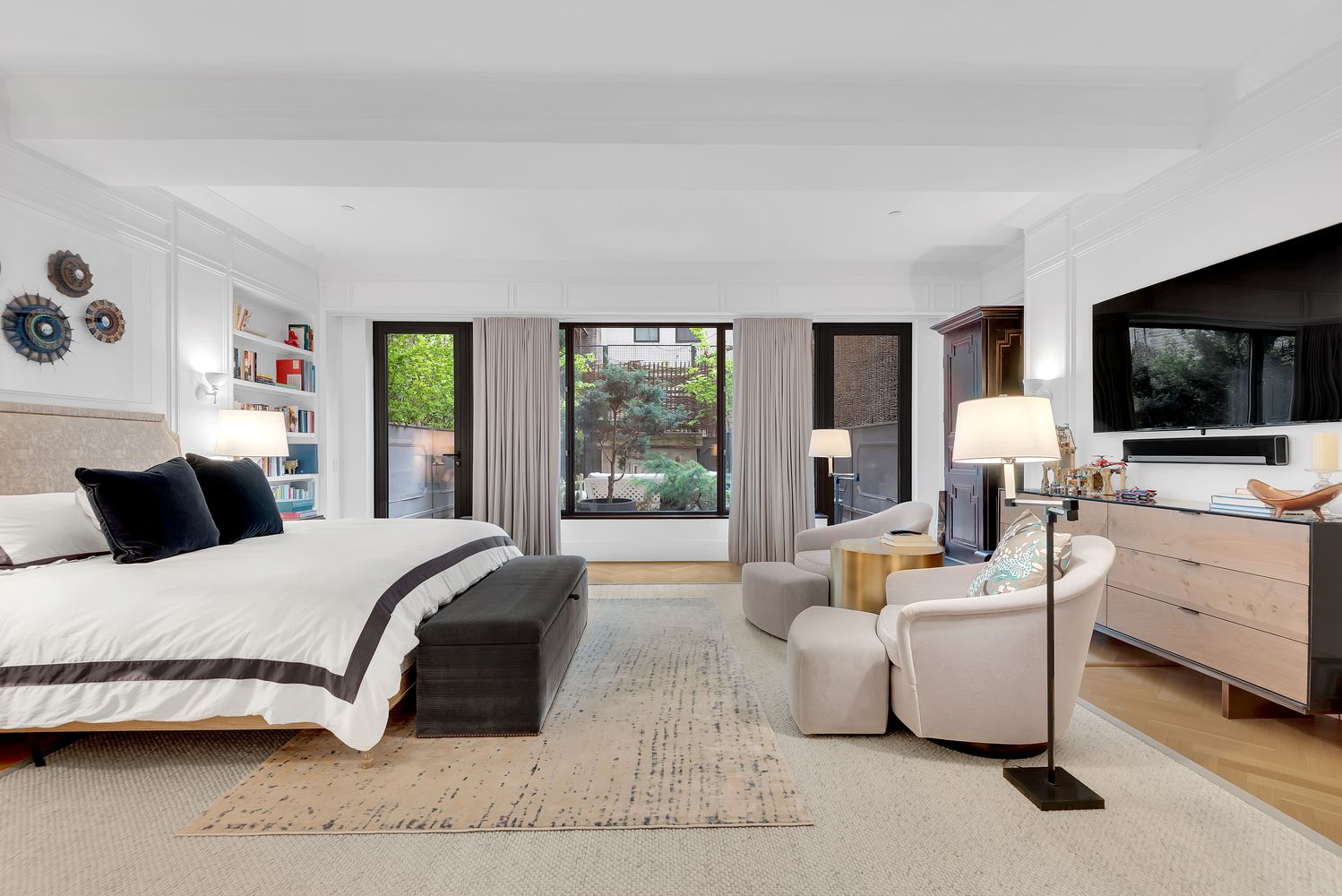 a bedroom with a large bed and a flat tv screen on dresser