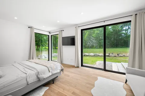 a bedroom with a large window and a bed