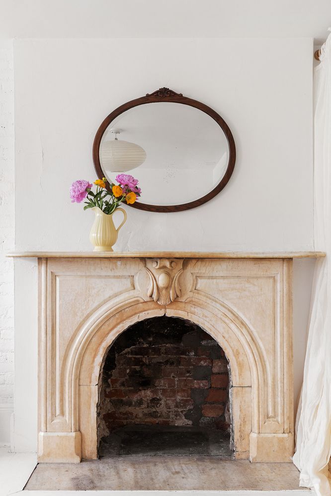 a living room with a fireplace and a potted plant