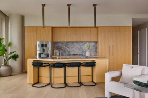 a kitchen with a table chairs and a potted plant