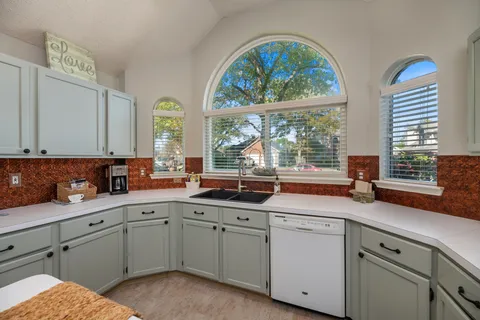 a kitchen with appliances cabinets and a large window