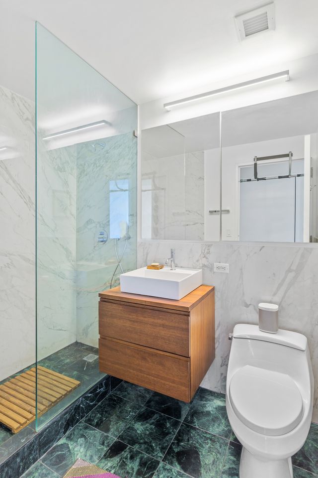 230 Ashland Place, Unit 26A Brooklyn, NY 11217 - Photo 6 of 12 a bathroom with a granite countertop sink a toilet and shower