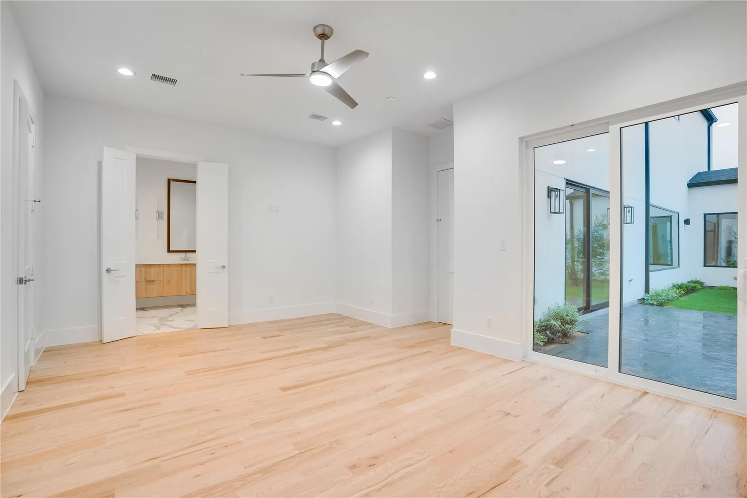 a view of an empty room with glass door and a chandelier