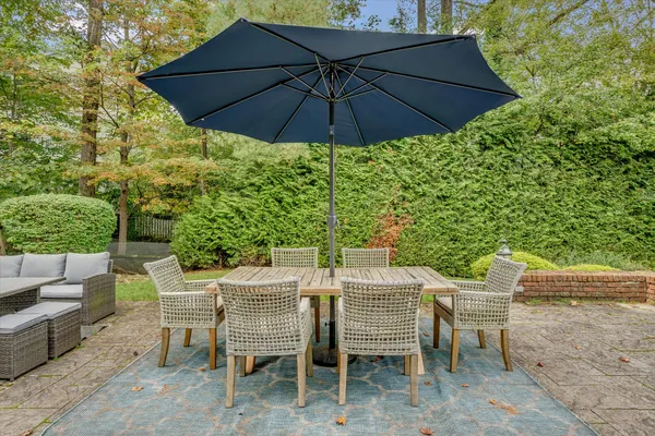 a view of an outdoor sitting area with chairs and an umbrella