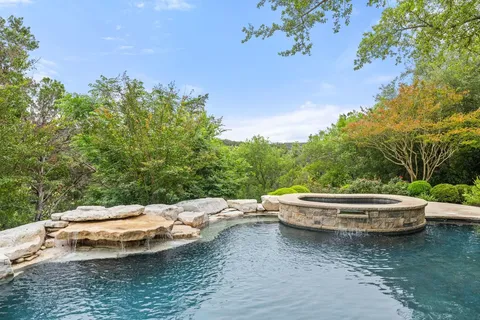 a small pool with some tall trees