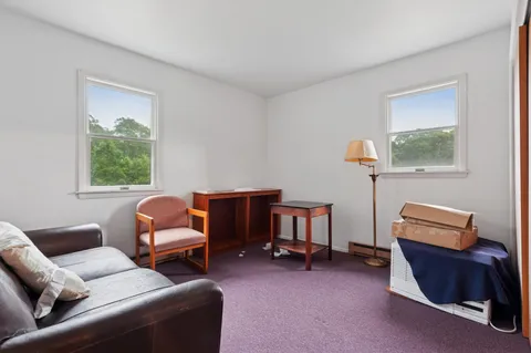 a living room with furniture a ceiling fan and a window