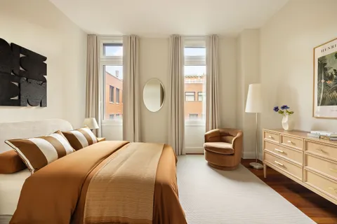 a bedroom with a bed a couch and dresser