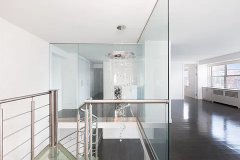 a view of a hallway with wooden floor and windows