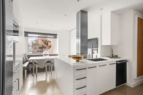 a room with stainless steel appliances furniture a large window and a refrigerator