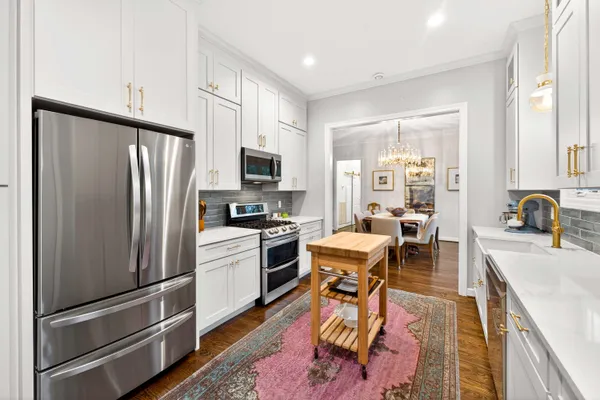 a kitchen with stainless steel appliances granite countertop a refrigerator stove microwave and sink