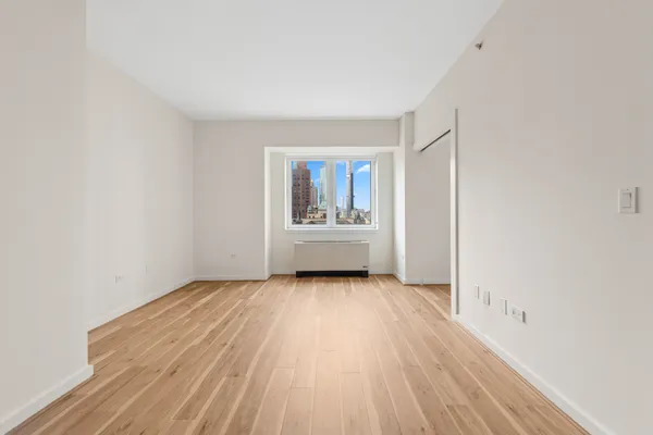 a view of a hallway with wooden floor and a living room