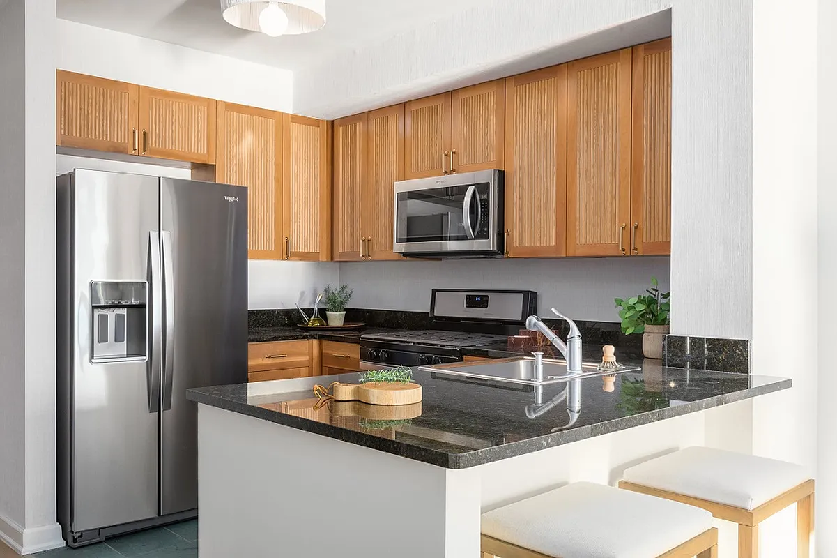 20 River Terrace, Unit 14C Manhattan, NY 10282 - Photo 3 of 18 a kitchen with stainless steel appliances granite countertop a refrigerator a stove a sink a counter space and cabinets