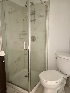 a white toilet next to a bathroom