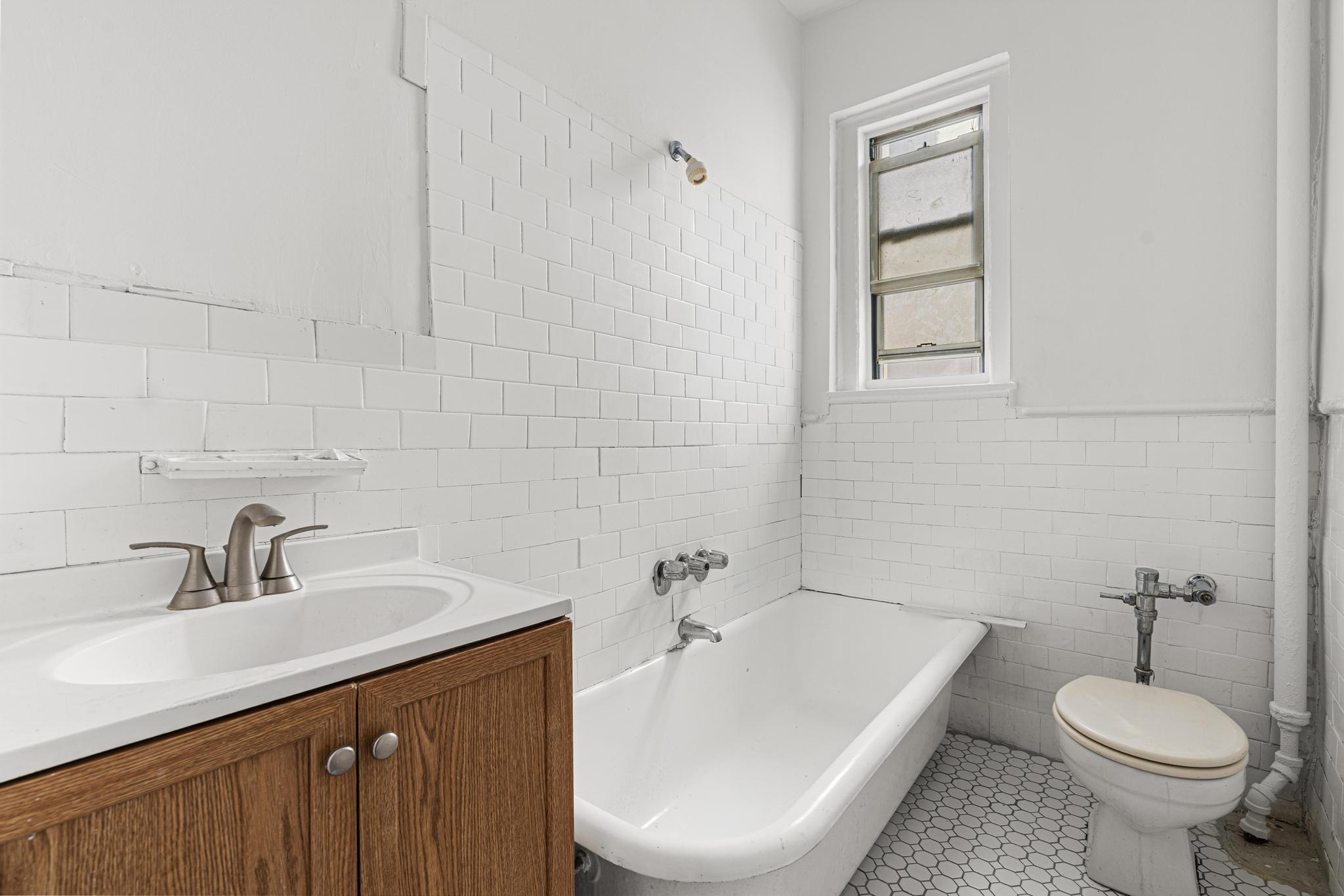1001 President Street, Unit L2 Brooklyn, NY 11225 - Photo 14 of 19 a bathroom with a sink a toilet and tub