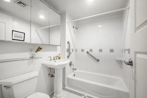 a bathroom with a sink mirror toilet and bathtub