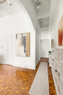 a view of a bedroom with wooden floor and bathroom