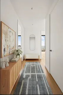 a view of entryway with a floor to ceiling window and wooden floor