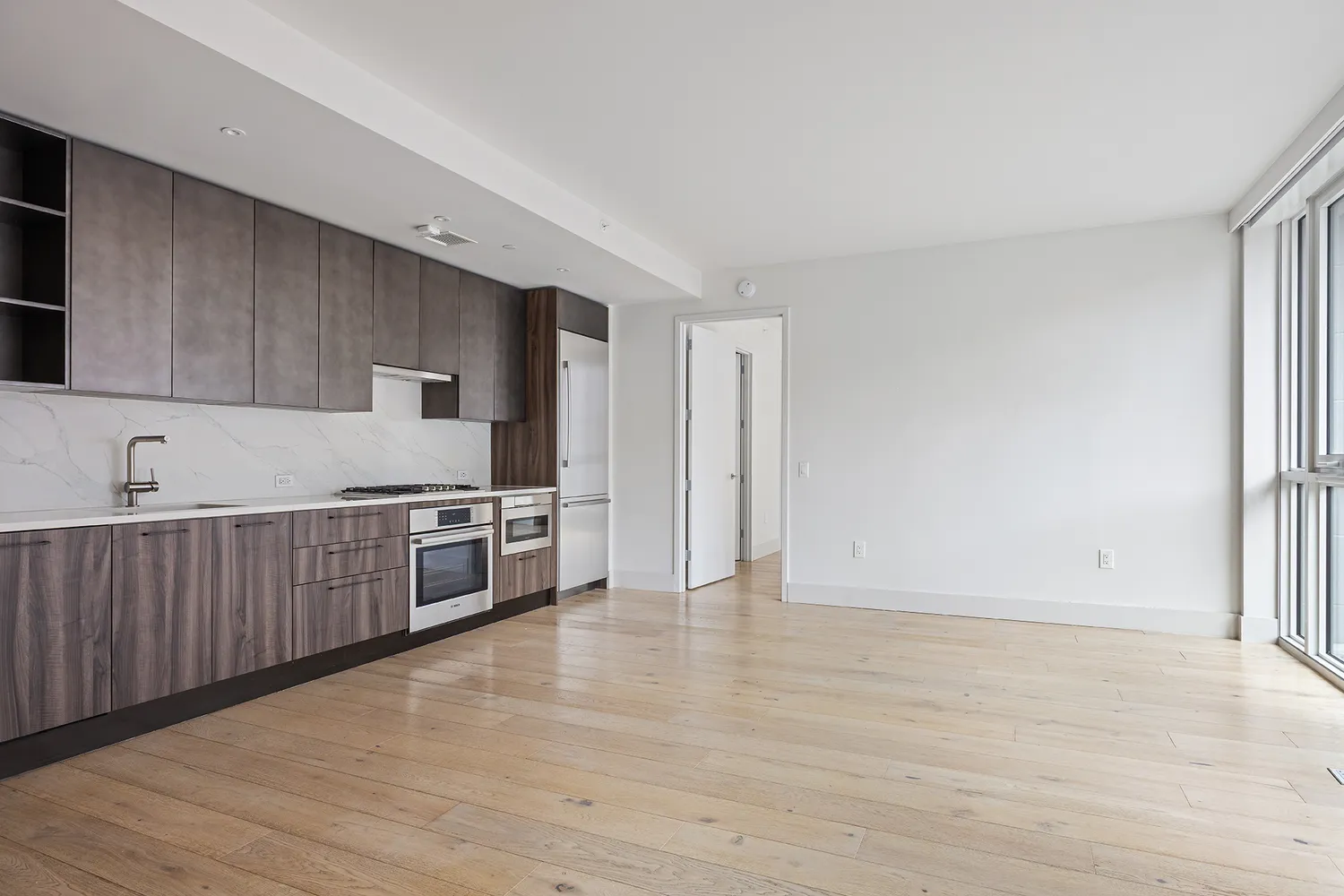 a kitchen with stainless steel appliances a refrigerator and a wooden floor