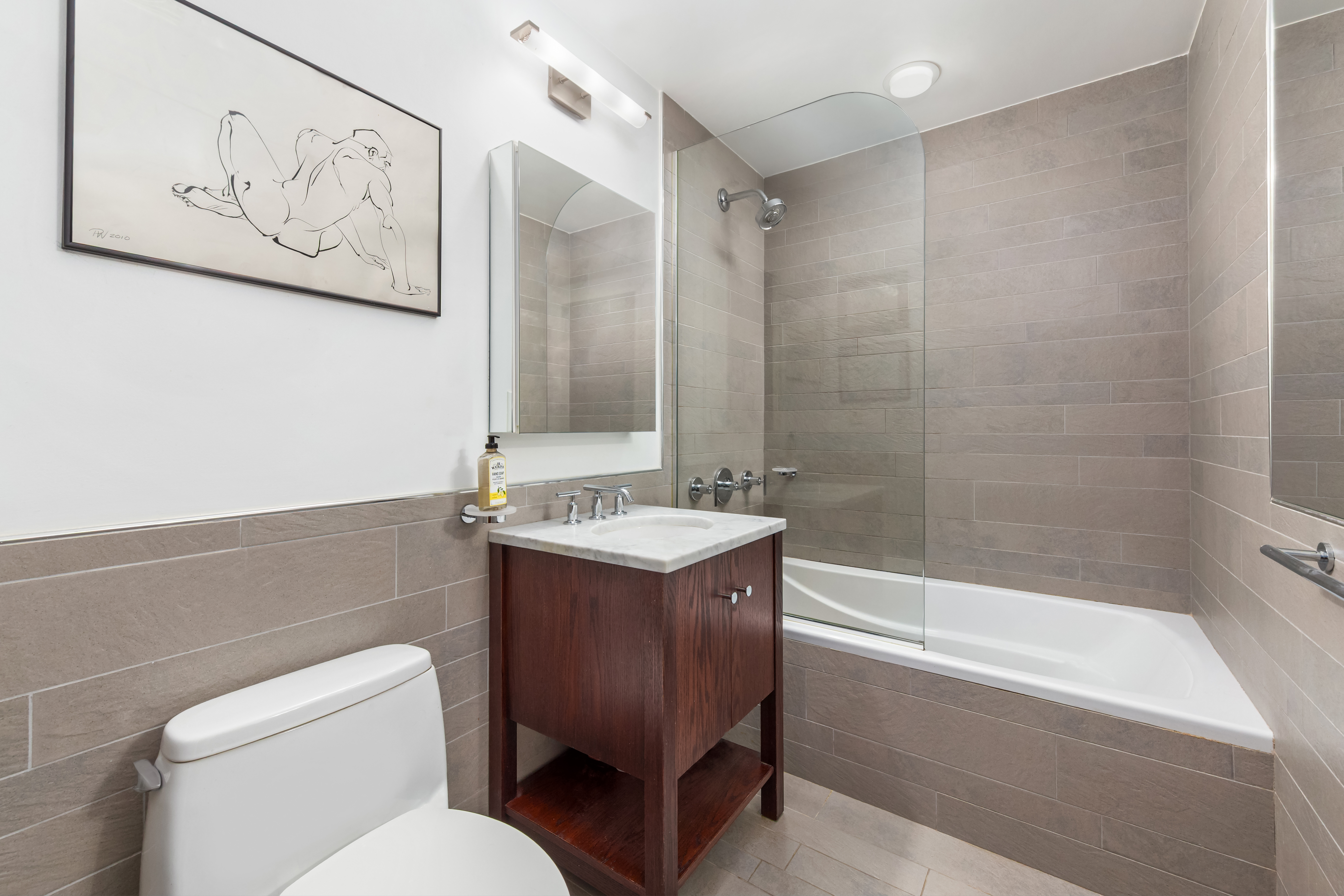 454 West 54th Street, Unit 7B Manhattan, NY 10019 - Photo 10 of 15 a bathroom with a bathtub shower sink and toilet