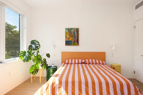 a bedroom with a bed and a potted plant
