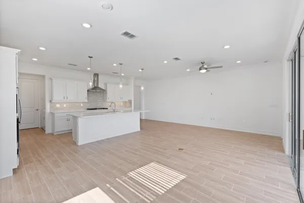 a large white kitchen with kitchen island a sink stainless steel appliances and cabinets