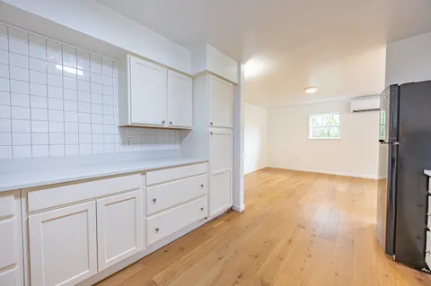 a kitchen with granite countertop white cabinets and refrigerator