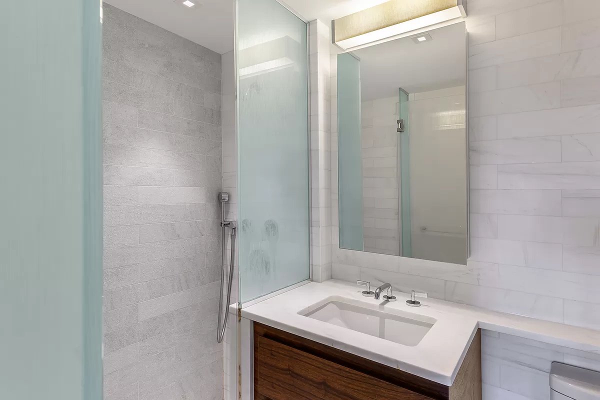 1280 5th Avenue, Unit 10A Manhattan, NY 10029 - Photo 8 of 15 a bathroom with a sink and a mirror