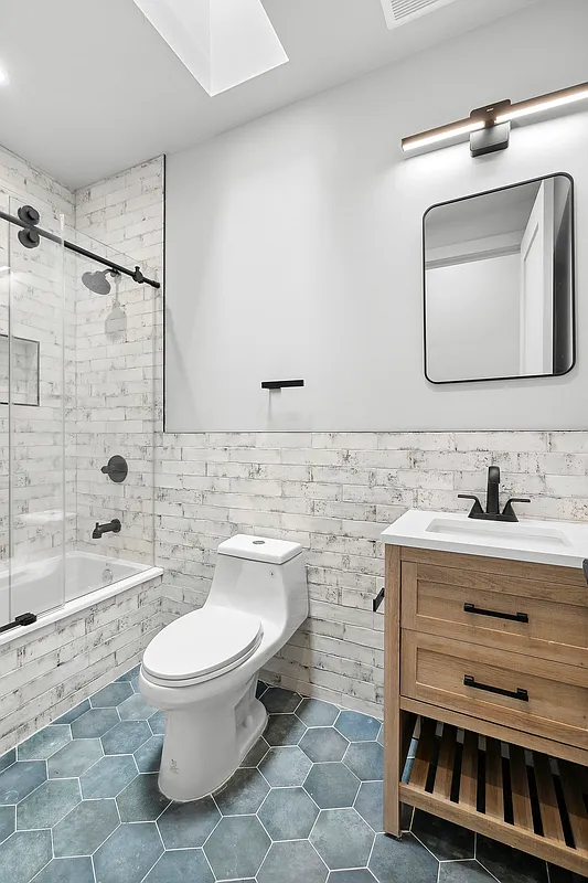 866 Bushwick Avenue, Unit 3 Brooklyn, NY 11221 - Photo 5 of 12 a bathroom with a toilet sink and mirror