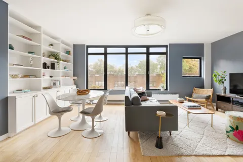 a dining room with wooden floor and white walls