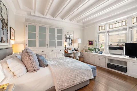 a bedroom with a large bed and a flat tv screen