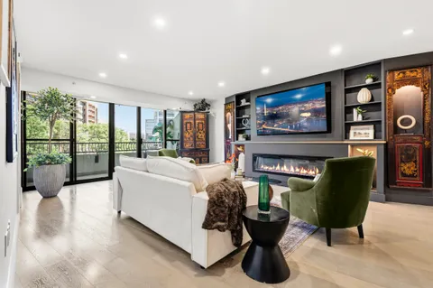 a living room with furniture a floor to ceiling window and a flat screen tv