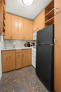 a kitchen with a refrigerator sink and cabinets
