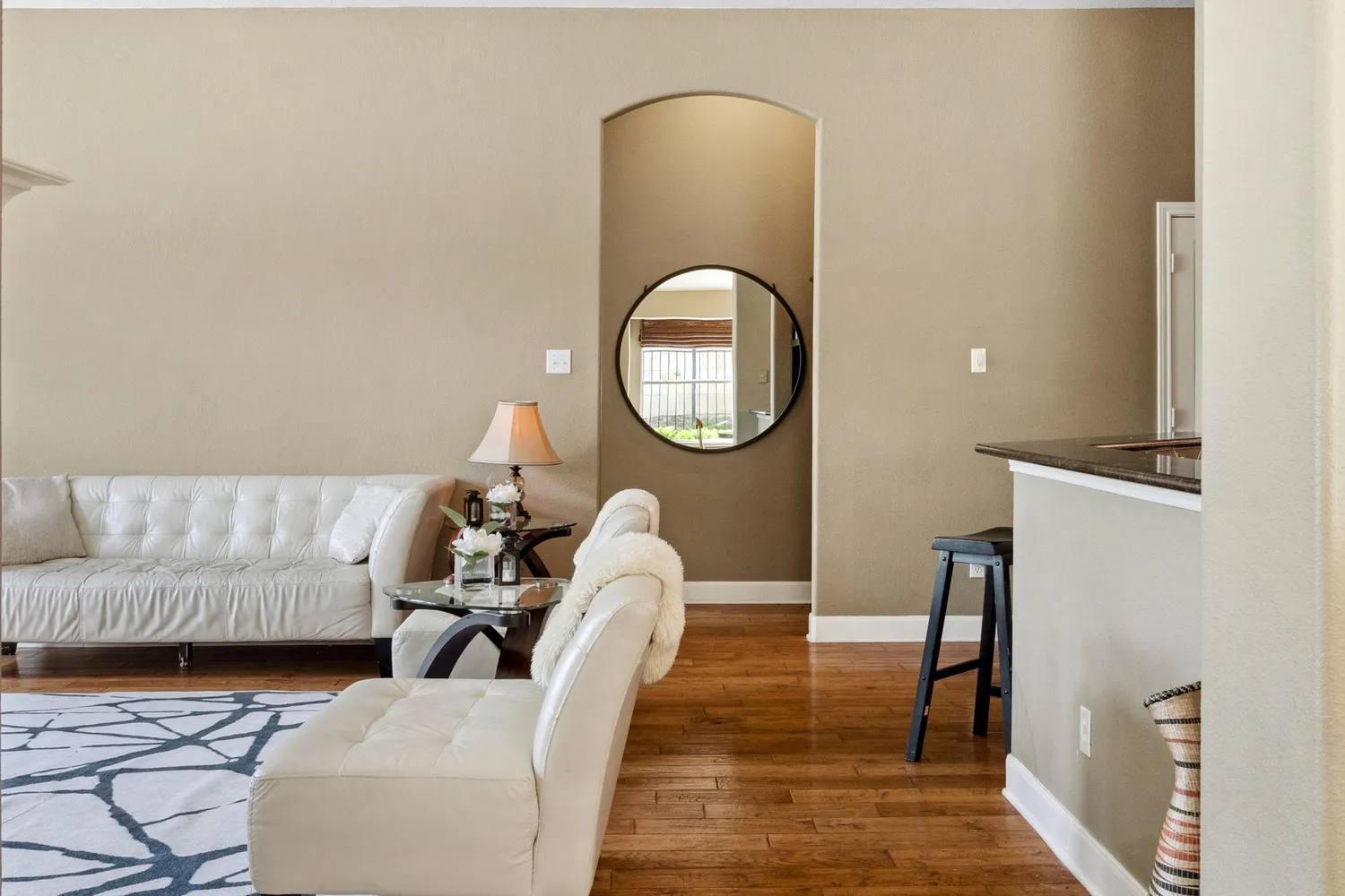 a living room with furniture and a mirror