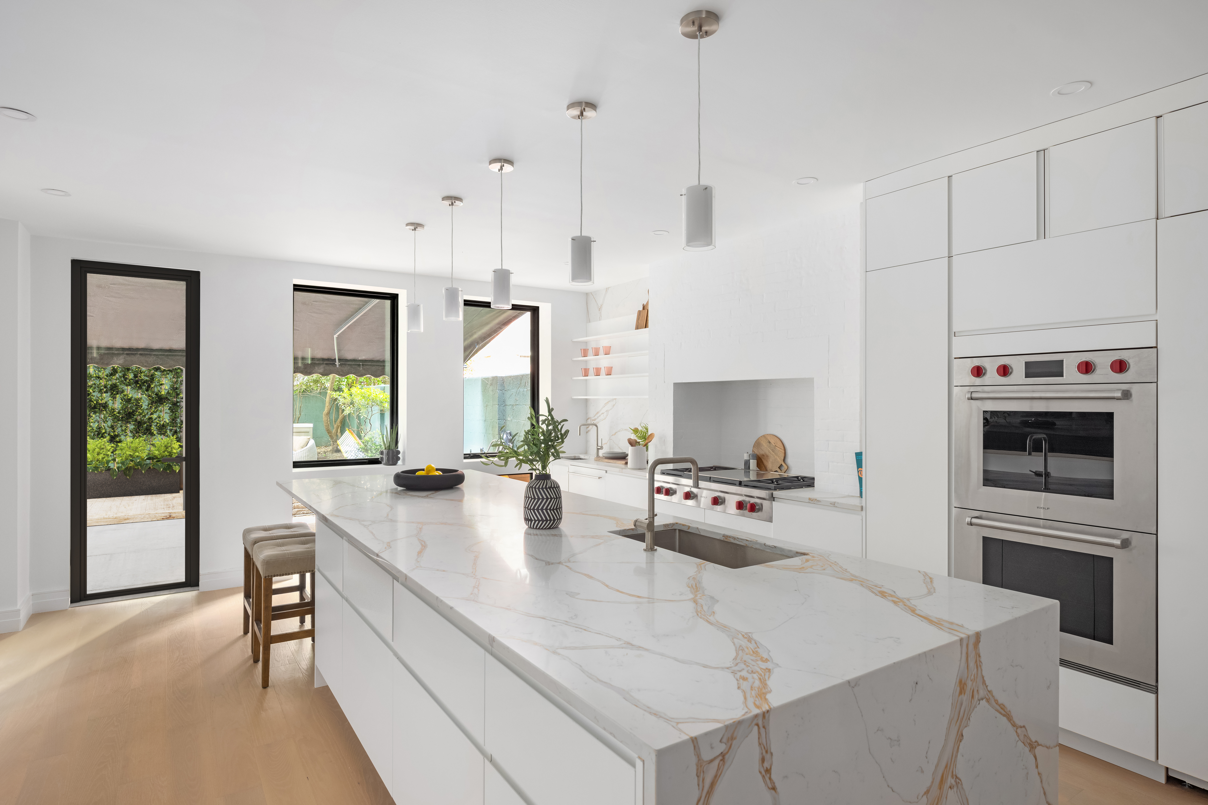 53 West 85th Street Manhattan, NY 10024 - Photo 7 of 37 a kitchen with stainless steel appliances granite countertop a stove a refrigerator a sink a dining table and chairs with wooden floor