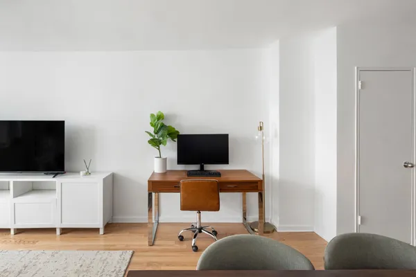a view of a workspace with a couch and a flat screen tv