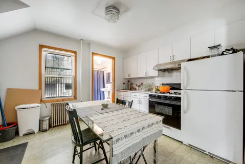 a kitchen with a refrigerator a stove a dining table and chairs