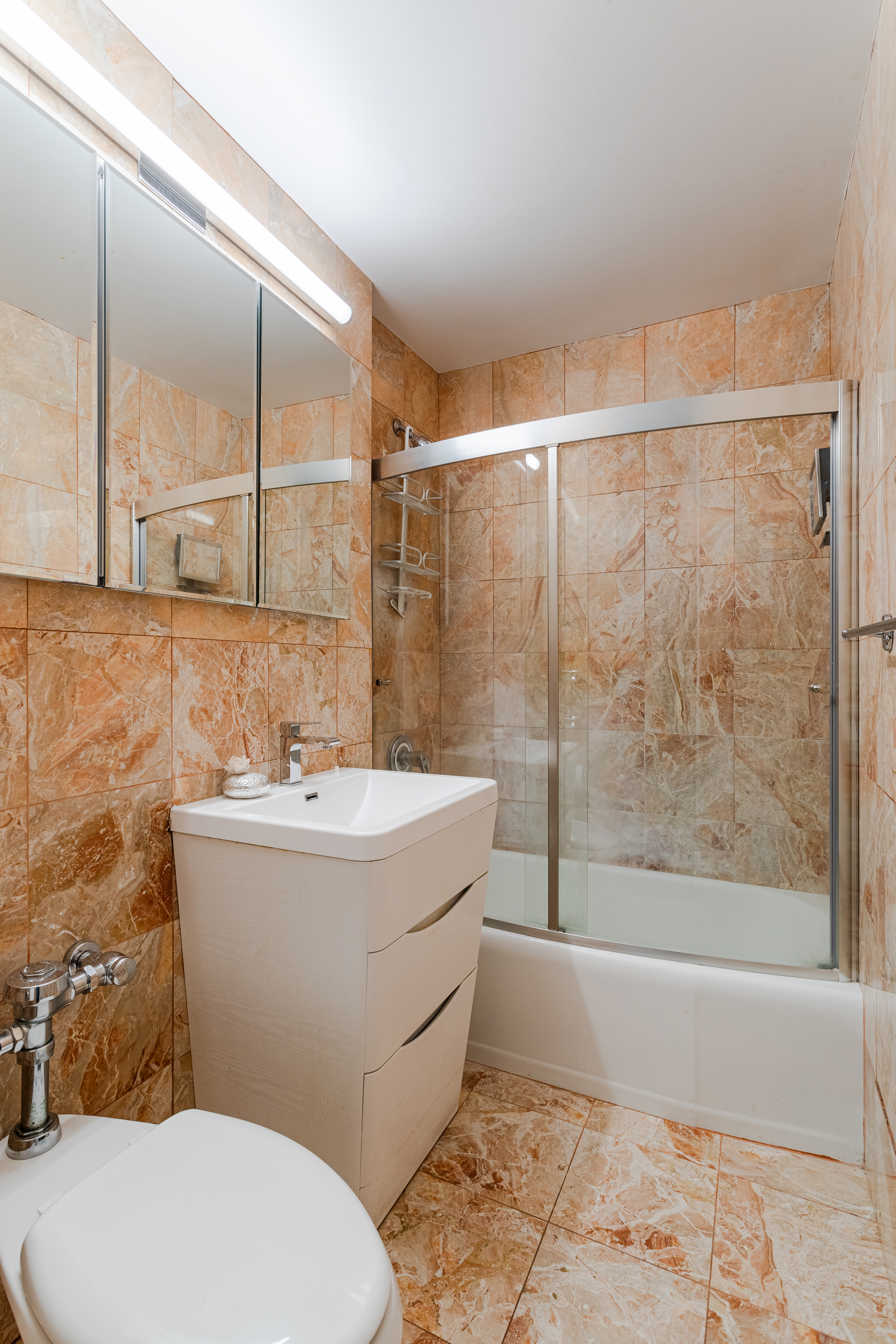 155 East 38th Street, Unit 10D Manhattan, NY 10016 - Photo 12 of 15 a bathroom with a sink mirror vanity and toilet