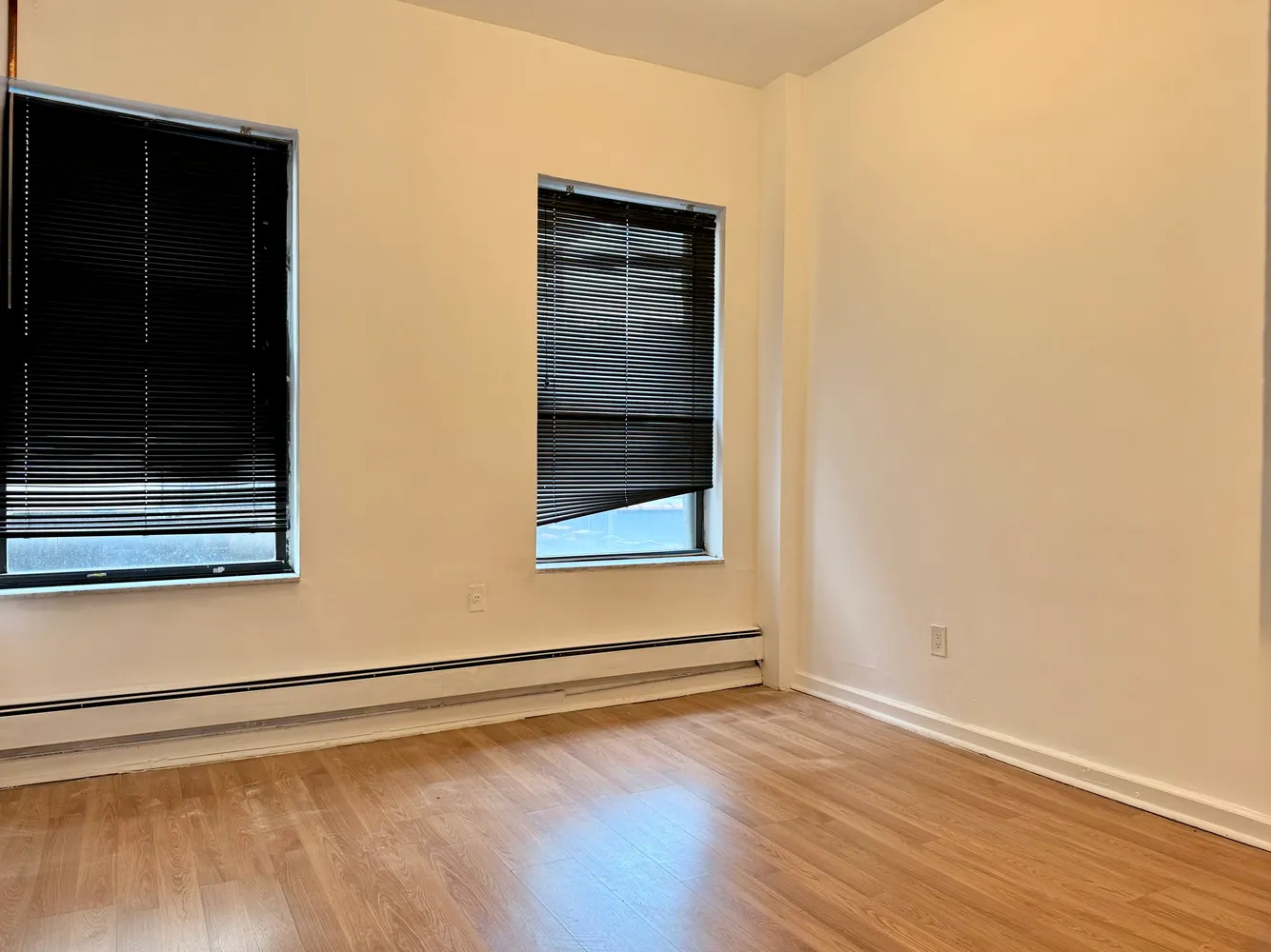 a view of a small space with wooden floor and a window