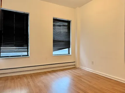 a view of a small space with wooden floor and a window