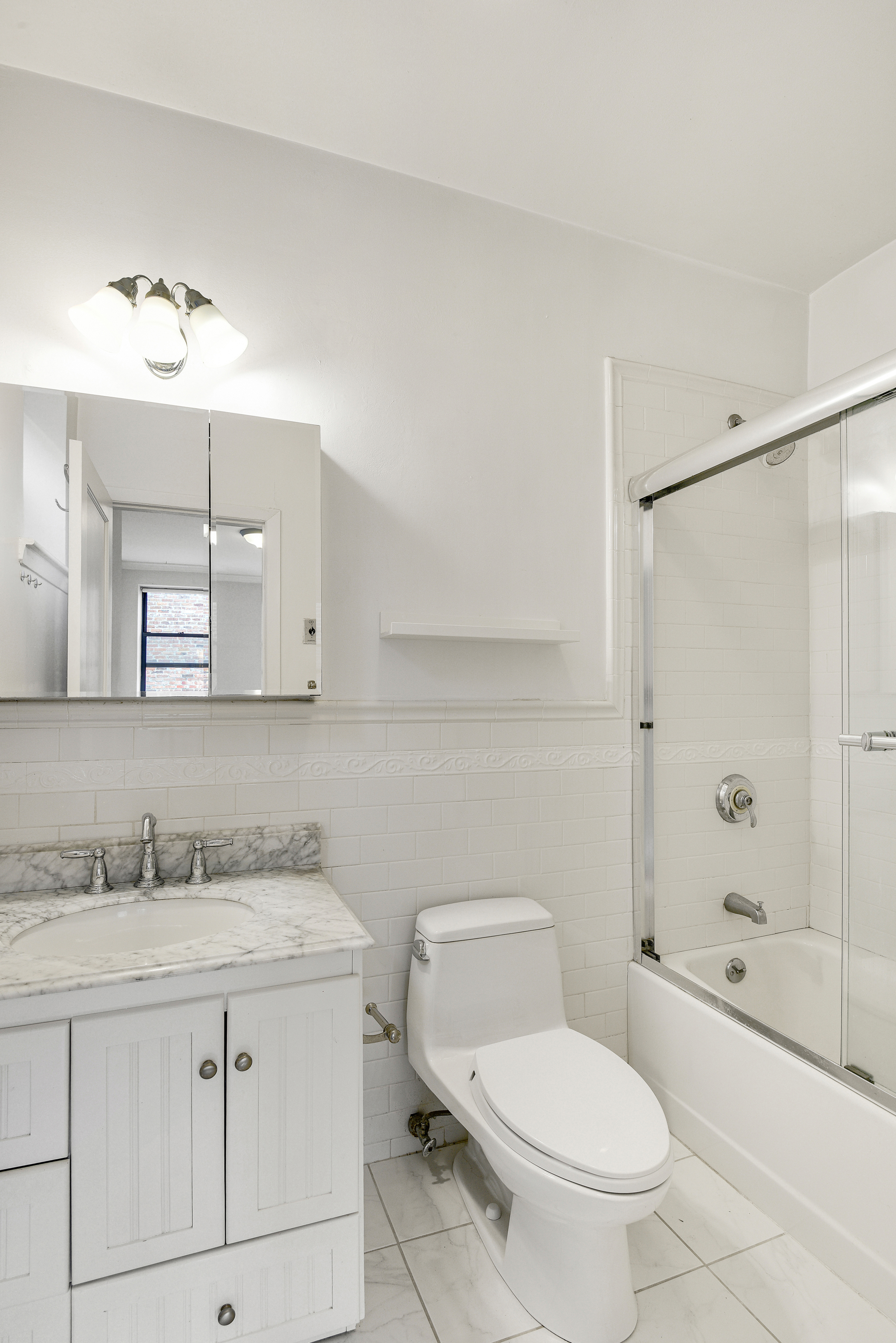 120 2nd Avenue, Unit 5A Manhattan, NY 10003 - Photo 7 of 10 a bathroom with a granite countertop sink toilet and shower