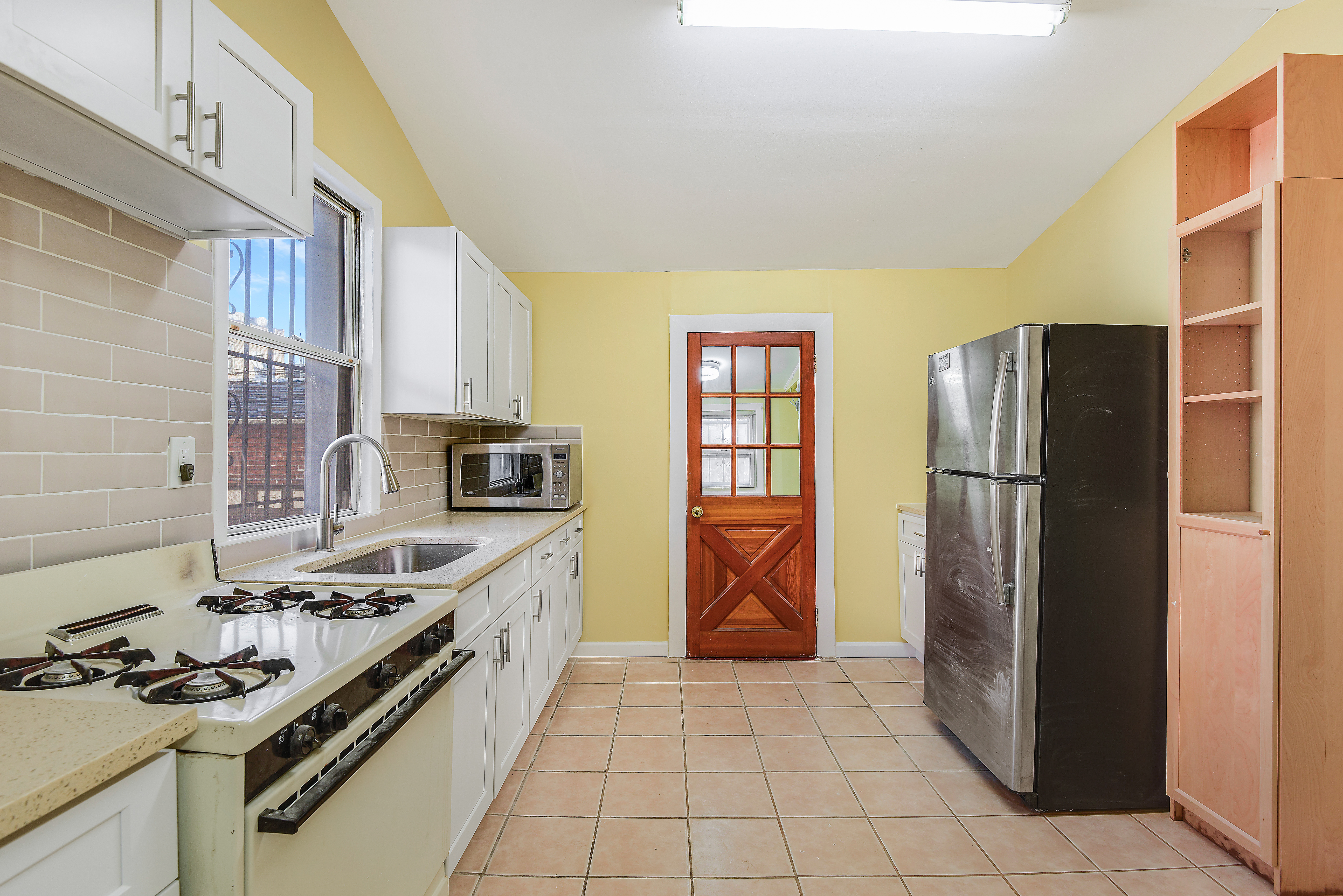 35-47 30th Street, Unit 1 Queens, NY 11106 - Photo 12 of 15 a kitchen with stainless steel appliances granite countertop a stove a refrigerator and a refrigerator