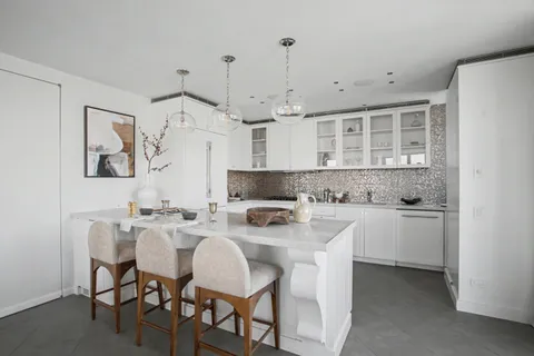 a kitchen with white cabinets and white appliances