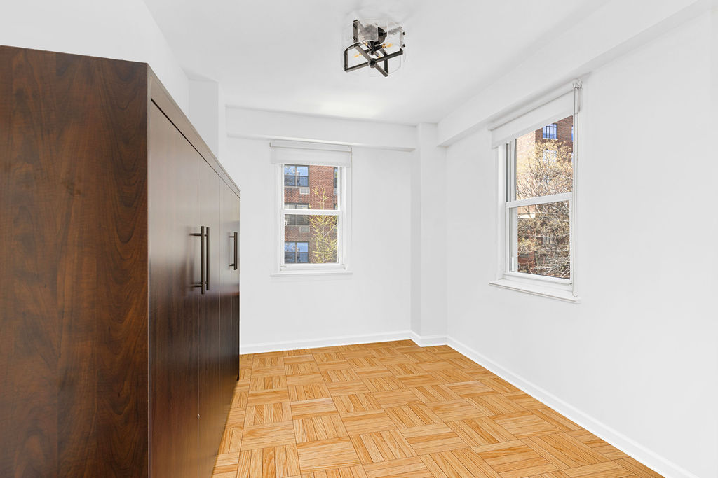 101 West 12th Street, Unit 5V Manhattan, NY 10011 - Photo 21 of 26 a view of an empty room with wooden floor and a window
