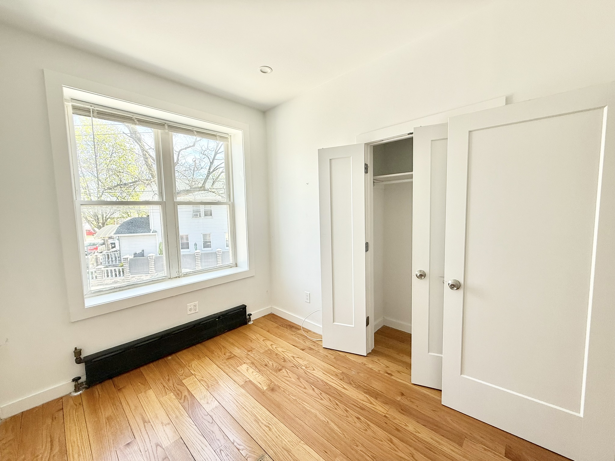 2013 Flatbush Avenue, Unit 2R Brooklyn, NY 11234 - Photo 6 of 11 an empty room with wooden floor and a window