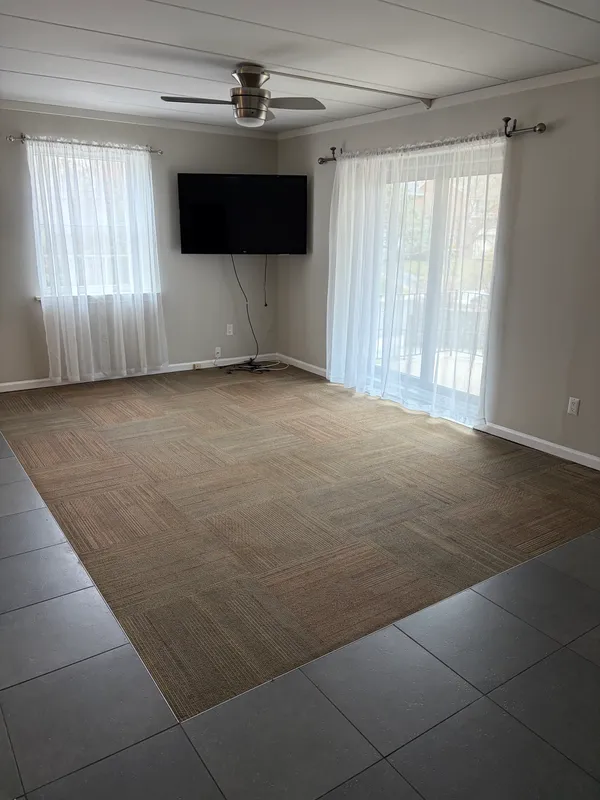 a view of an empty room with a window and a ceiling fan