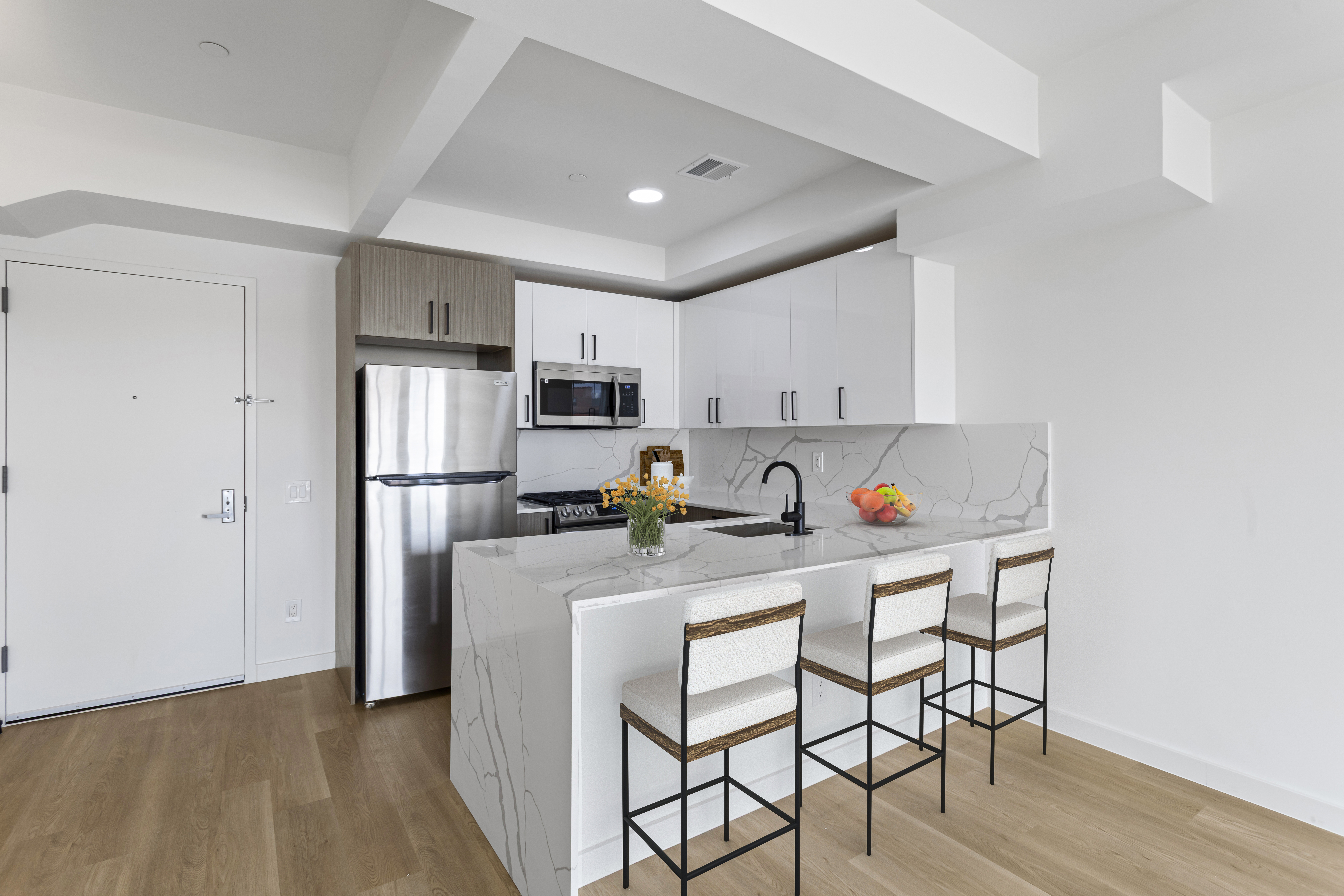 3144 Emmons Avenue, Unit 102 Brooklyn, NY 11235 - Photo 3 of 12 a kitchen with stainless steel appliances granite countertop a refrigerator a stove a sink dishwasher and white cabinets with wooden floor