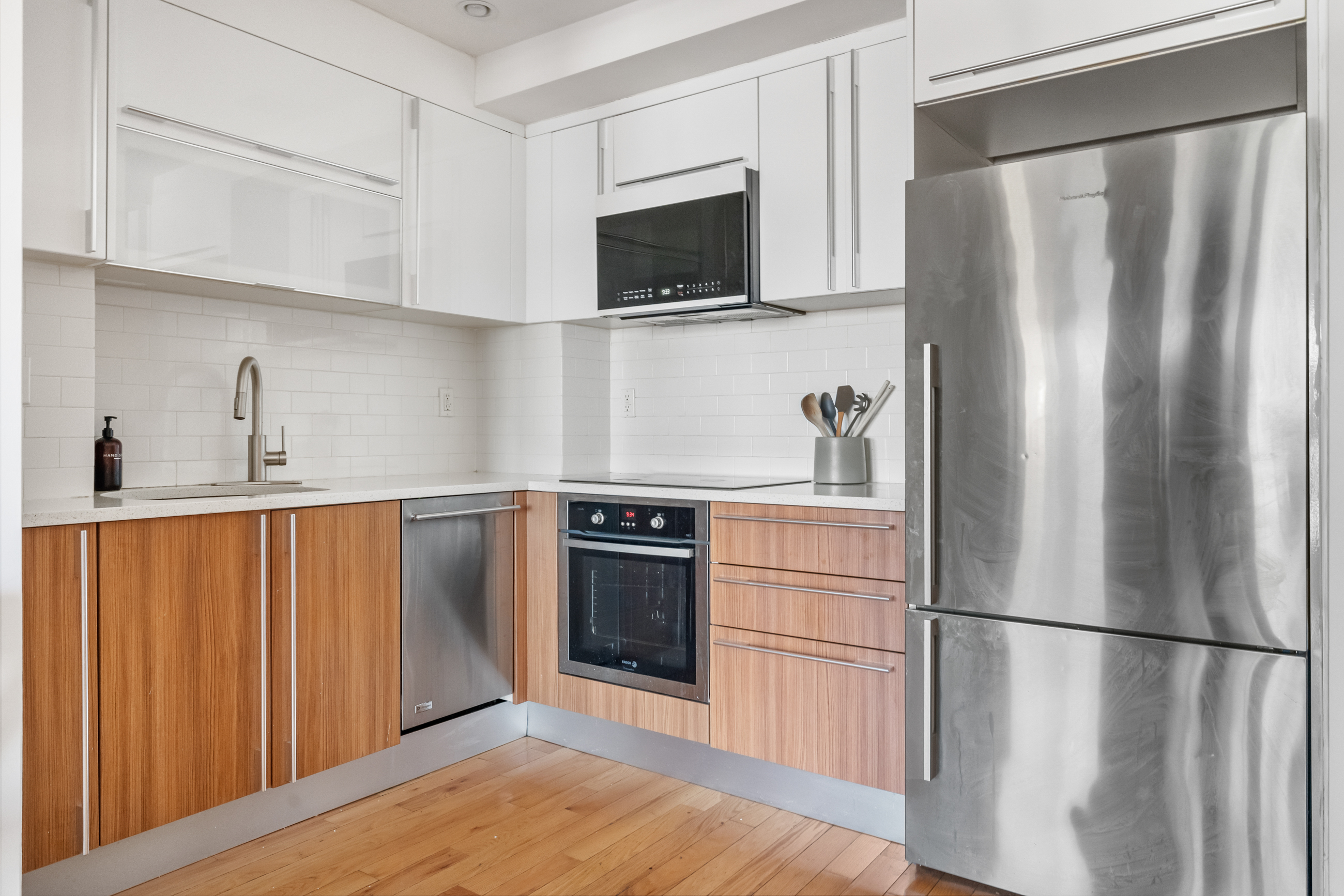 31-35 31st Street, Unit 512 Queens, NY 11106 - Photo 4 of 6 a kitchen with stainless steel appliances a refrigerator sink and microwave