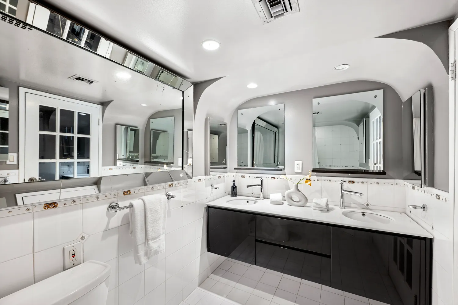 a bathroom with a double vanity sink and mirror with bathtub