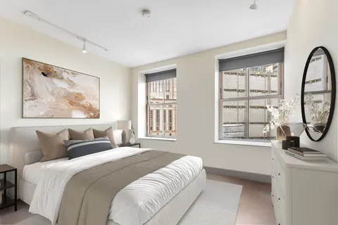 a bedroom with a bed a mirror and windows