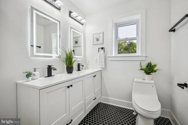 a bathroom with a sink a toilet and a mirror